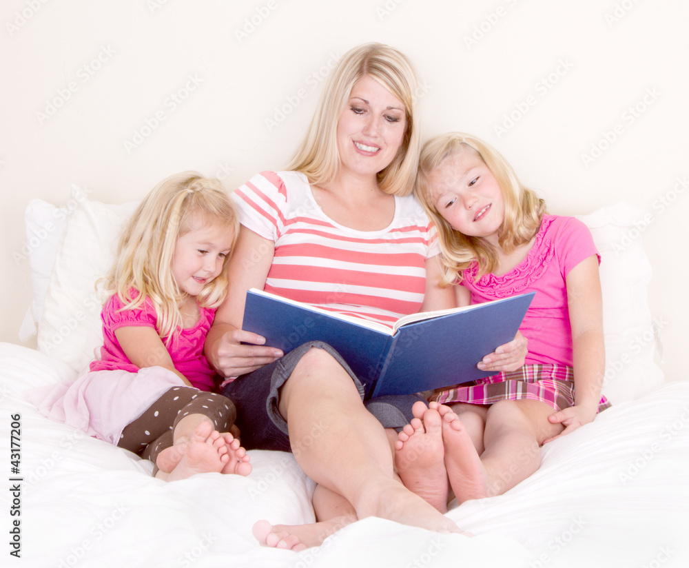 Family on bed reading book