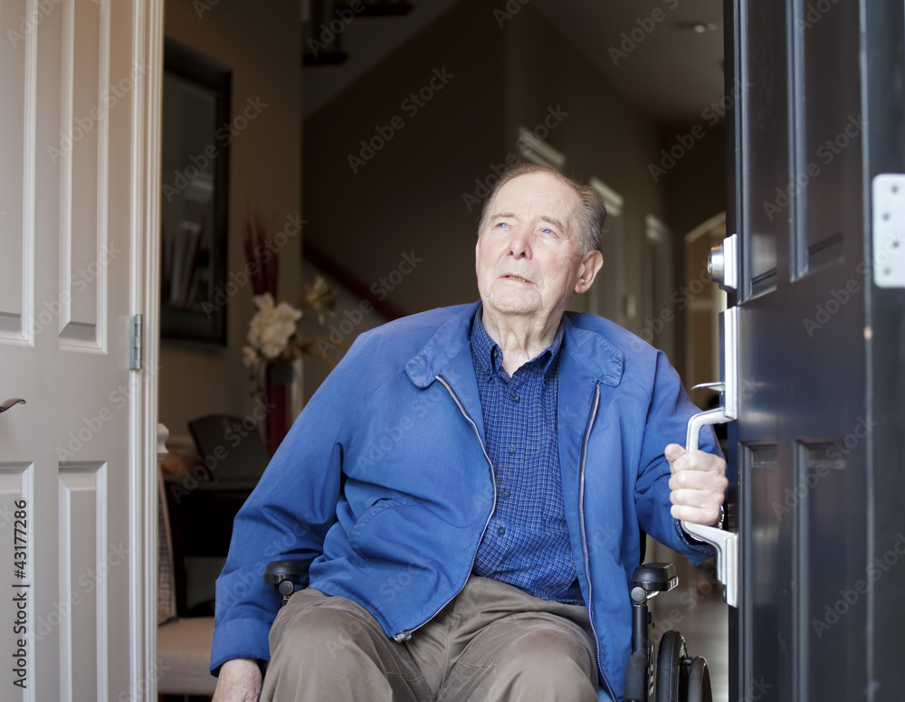 Elderly man in wheelchair at his front door, looking up Elderly man in wheelchair at his front door, looking up