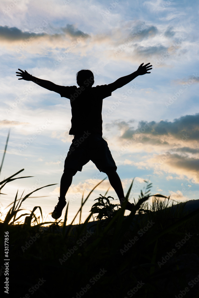 Happy man silhouette on the sunset