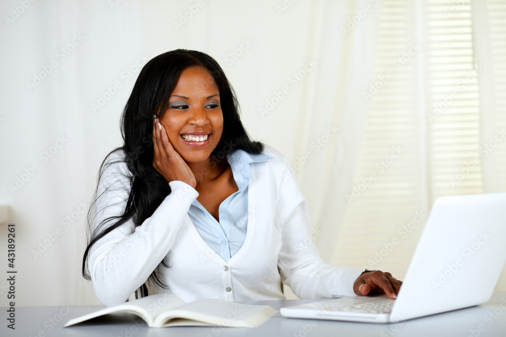 Lovely student woman smiling and looking to laptop Lovely student woman smiling and looking to laptop