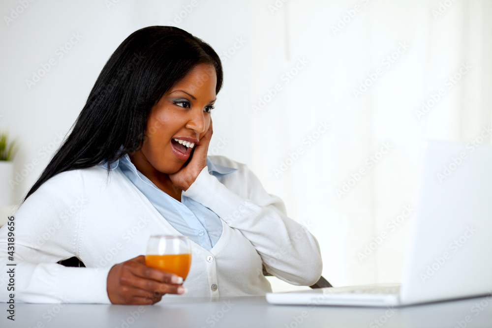 Surprised young woman looking to laptop screen Surprised young woman looking to laptop screen