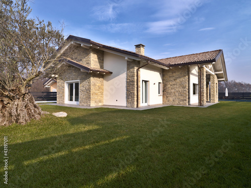 villa moderna con giardino e muri di pietra