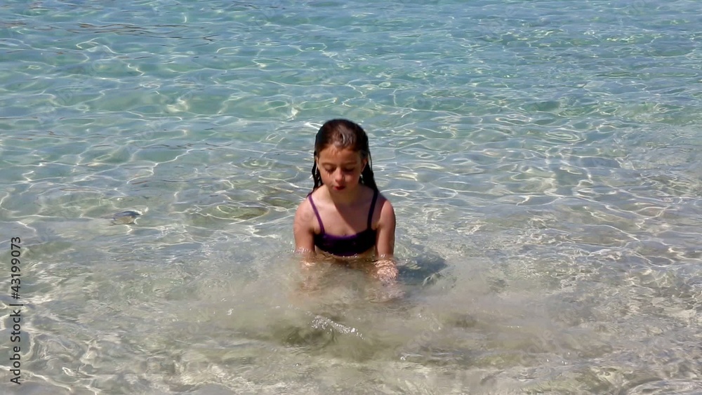 beautiful little girl playing in ibiza beach on vacation