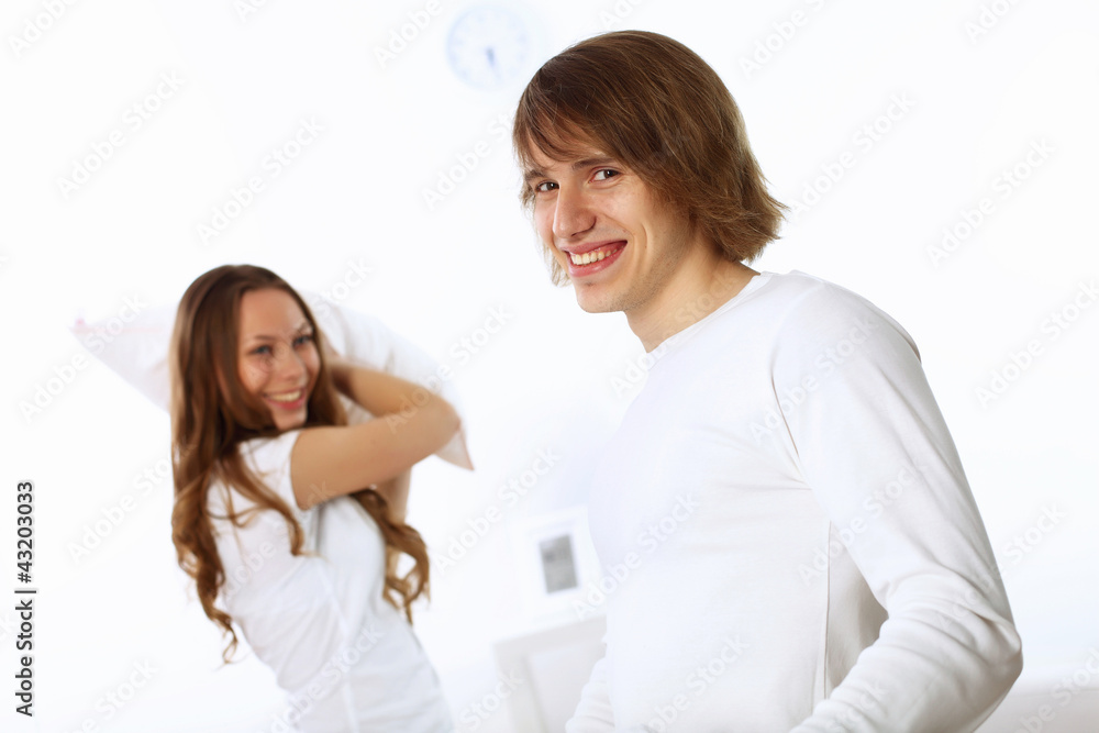 Young couple fighting with pillows Young couple fighting with pillows