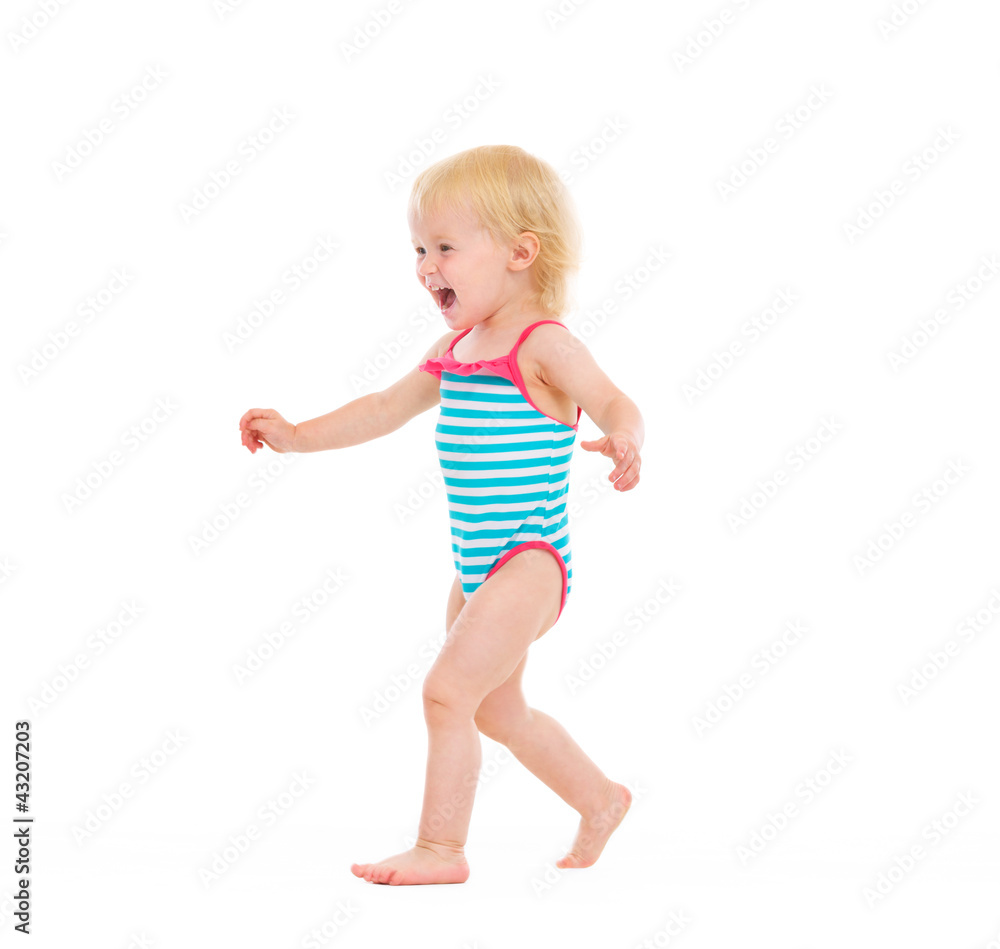 Happy baby in swimsuit running on white Happy baby in swimsuit running on white