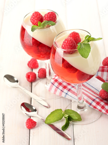fruit jelly with raspberries in glasses on wooden table