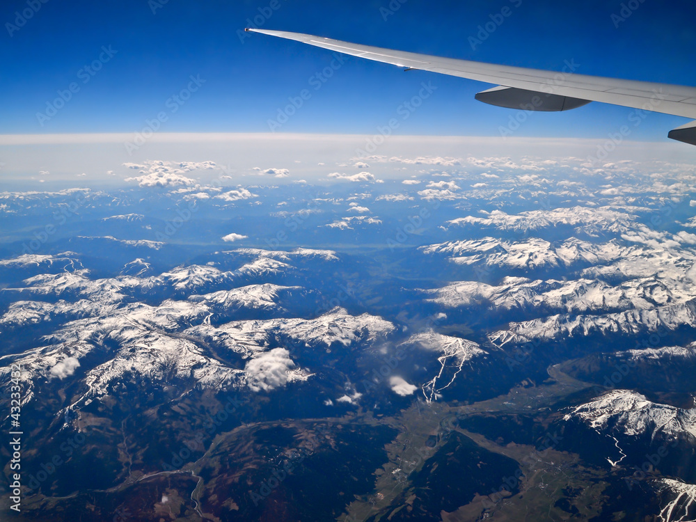 air plane wing and blue sky over the Alps
