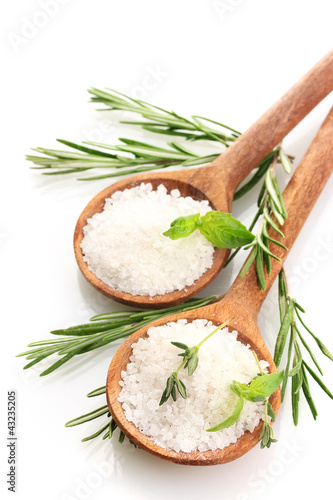salt in spoons with fresh basil, thyme and rosemary isolated