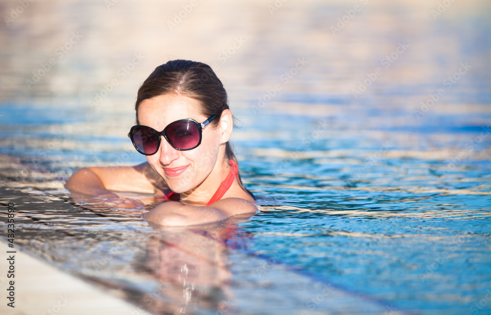 Portrait of a young woman relaxing in a swimming pool 