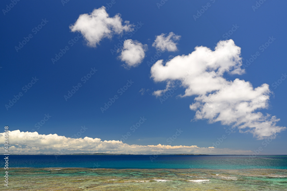 南国沖縄の綺麗なサンゴの海と夏空
