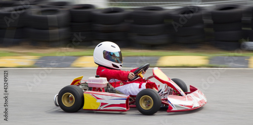 Young asian boy racing in a go kart