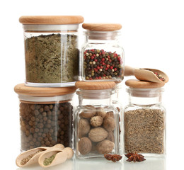 Fototapete Gewürze jars and wooden spoons with spices isolated on white  © Africa Studio