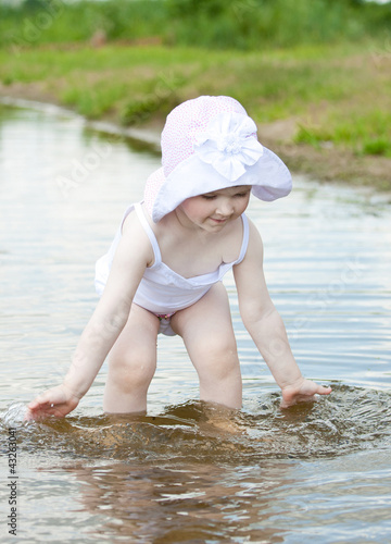 Fototapeta Naklejka Na Ścianę i Meble -  Cute little girl playing in water