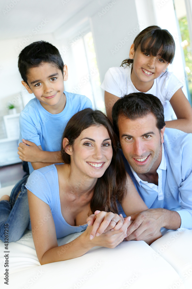 Portrait of happy family laying down bed