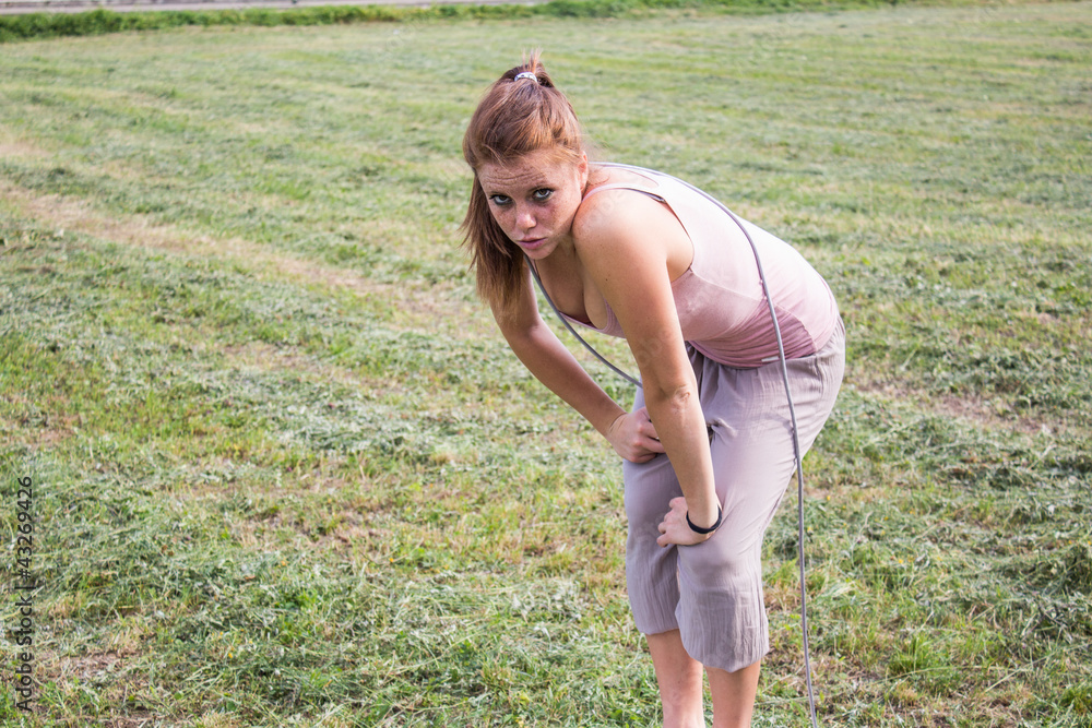 Sensual and tired girl keep fit in a urban landscape