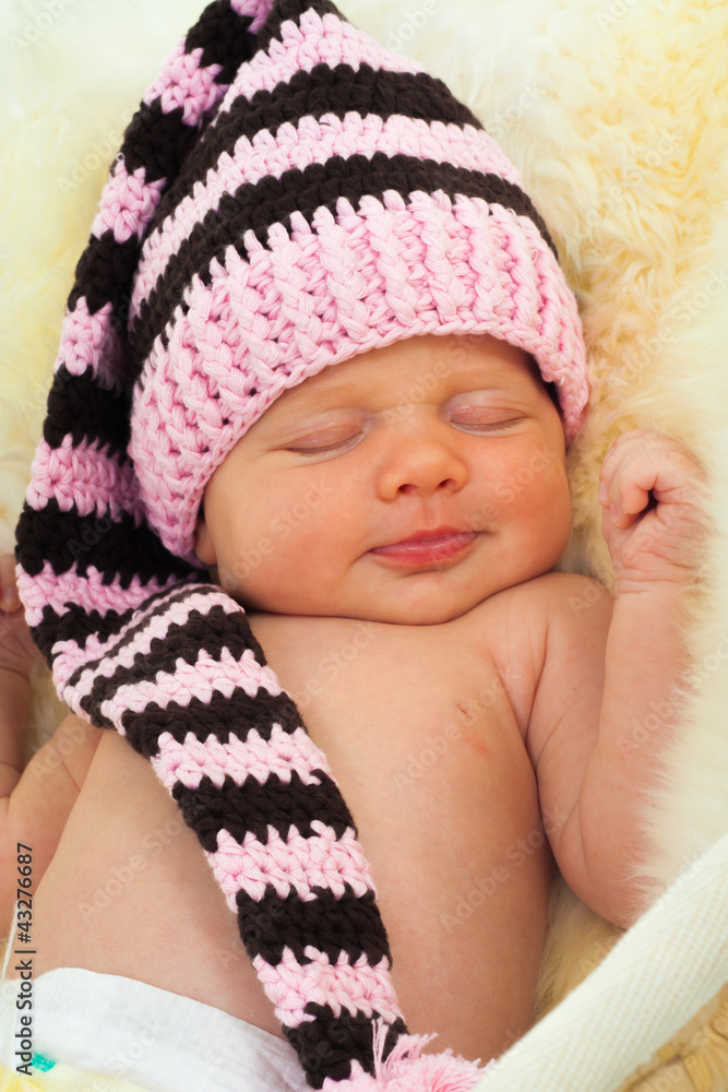 infant sleeping on a white sheepskin in a wicker basket. infant sleeping on a white sheepskin in a wicker basket.