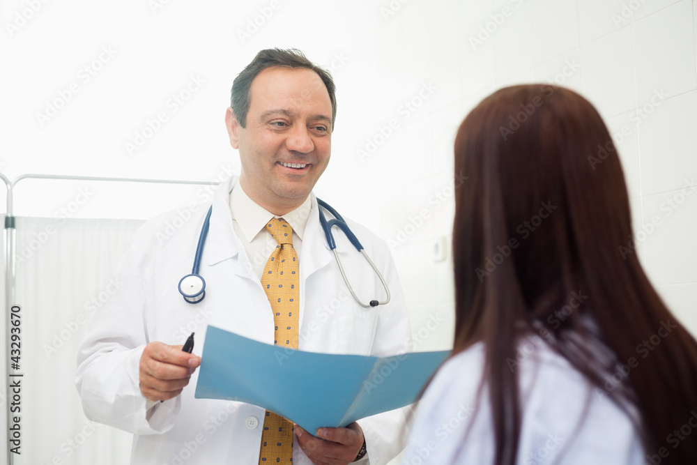 Doctor holding a document while talking to a patient Doctor holding a document while talking to a patient