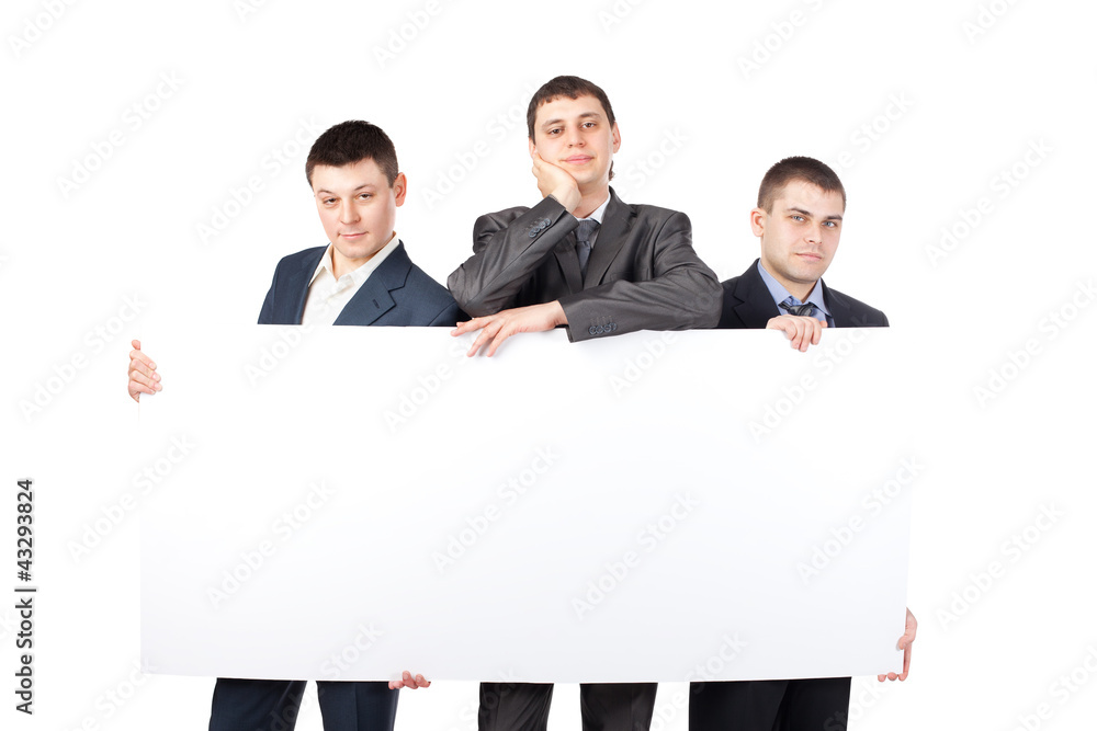Three young businessmen hold up a large blank sign isolated Three young businessmen hold up a large blank sign isolated