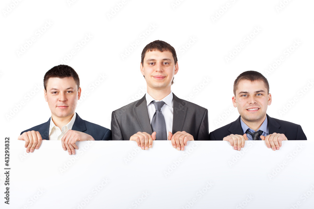 Three young businessmen hold up a large blank sign isolated Three young businessmen hold up a large blank sign isolated