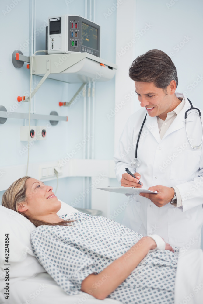 Doctor standing while holding a chart Doctor standing while holding a chart