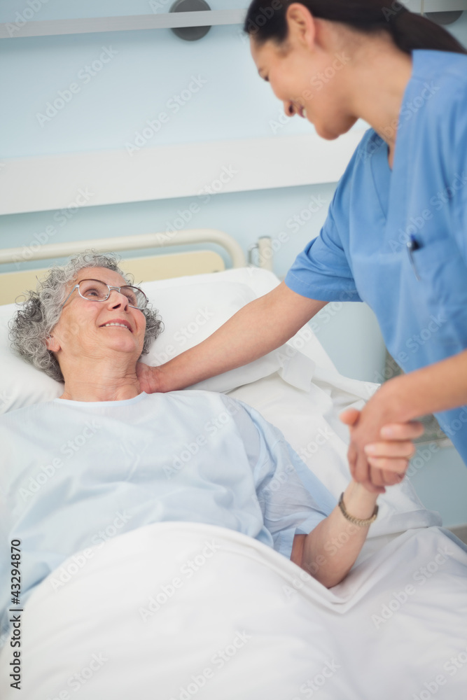 Obraz premium Patient smiling to a nurse while holding her hand