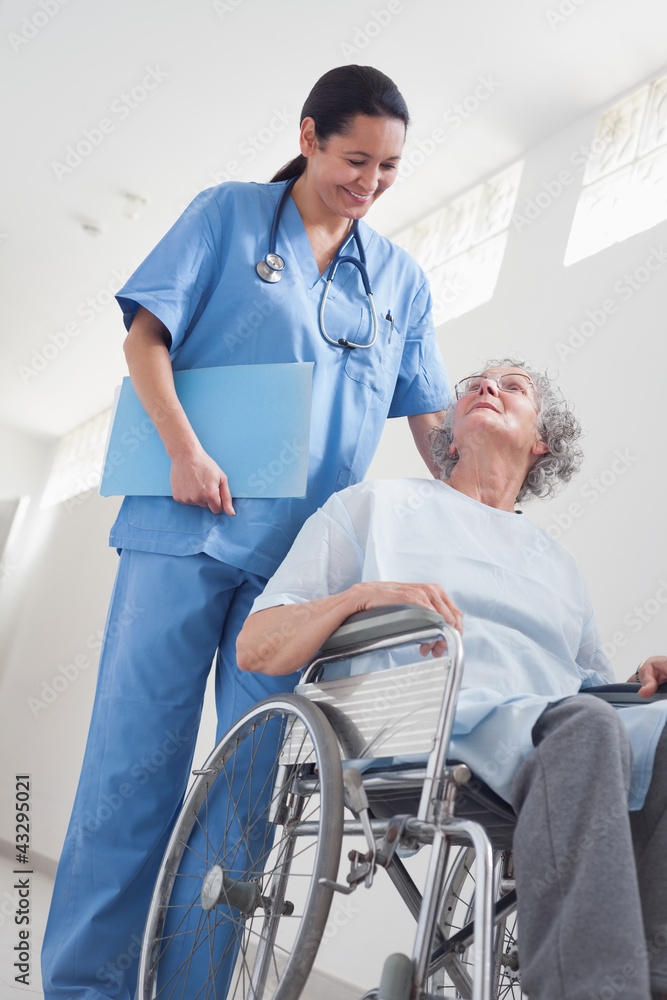 Elderly patient in a wheelchair next to a nurse Elderly patient in a wheelchair next to a nurse