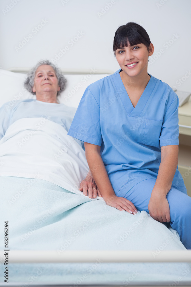 Obraz premium Nurse sitting on a medical bed