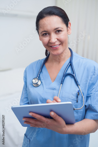 Nurse looking at camera while holding an ebook