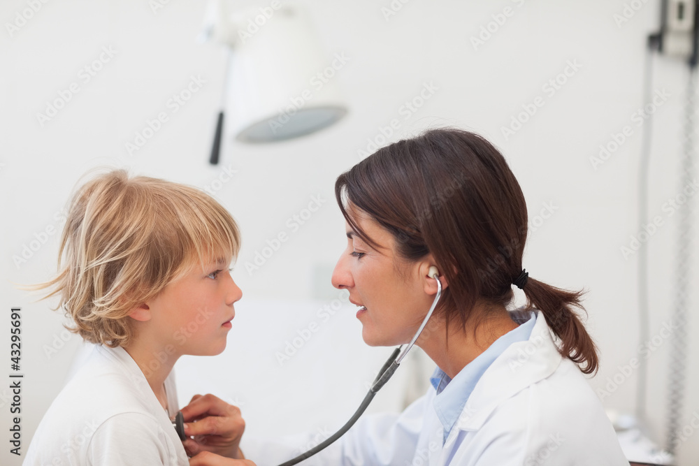 Doctor auscultating a child with a stethoscope Doctor auscultating a child with a stethoscope
