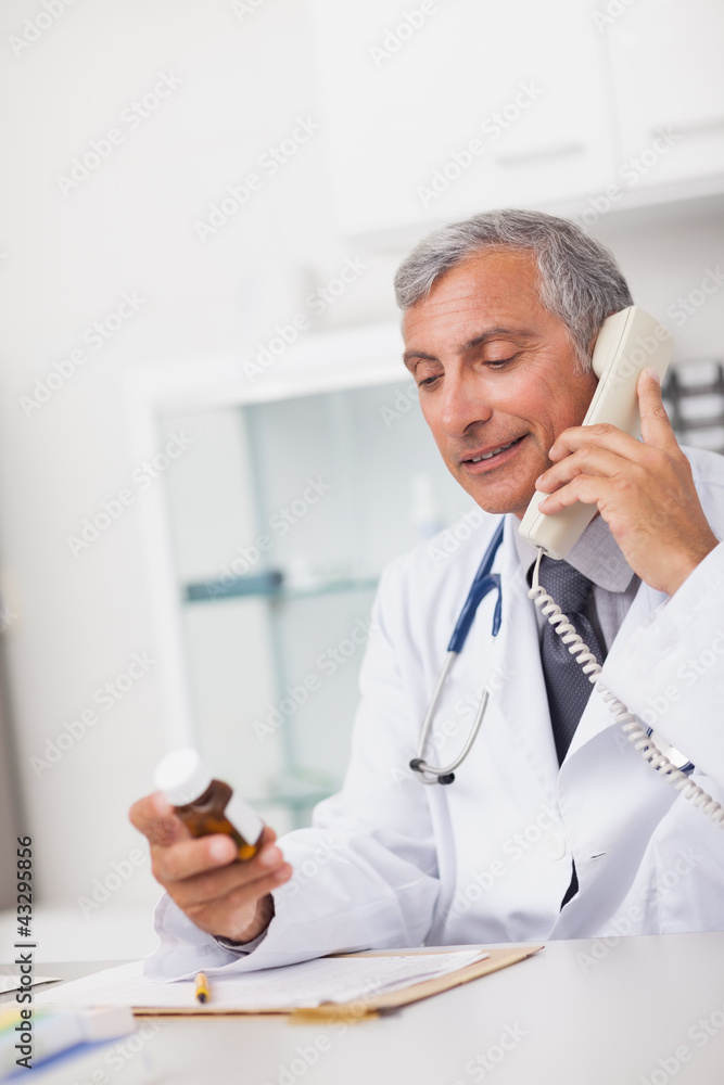 Doctor holding a drug box and a phone Doctor holding a drug box and a phone