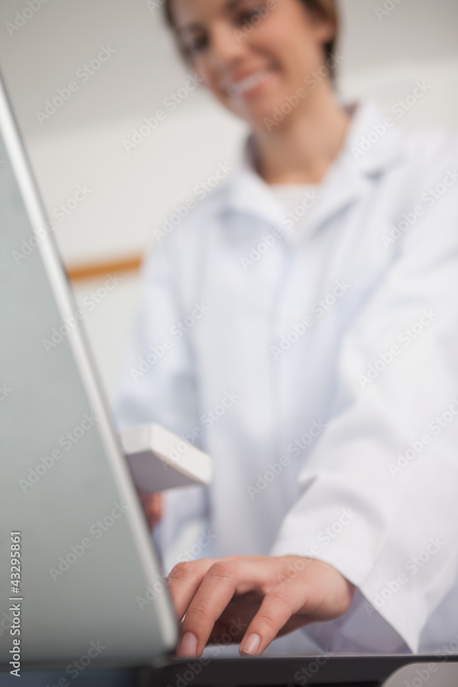 Pharmacist typing on a laptop Pharmacist typing on a laptop