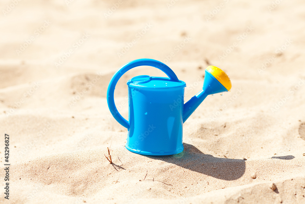 watering can on a background of sand watering can on a background of sand