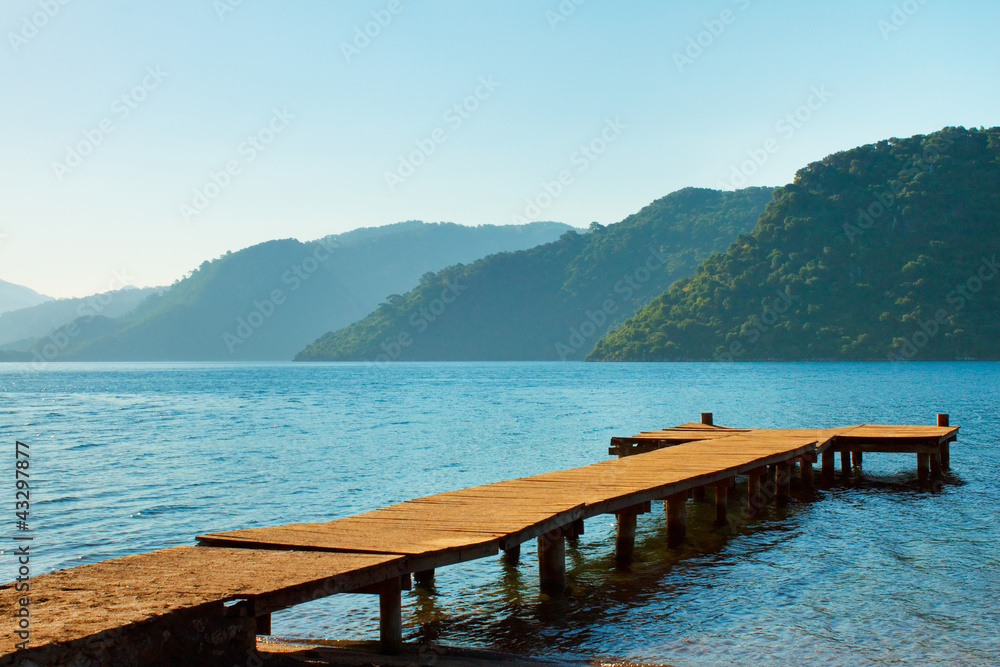 mountains and old wooden pier to the sea.