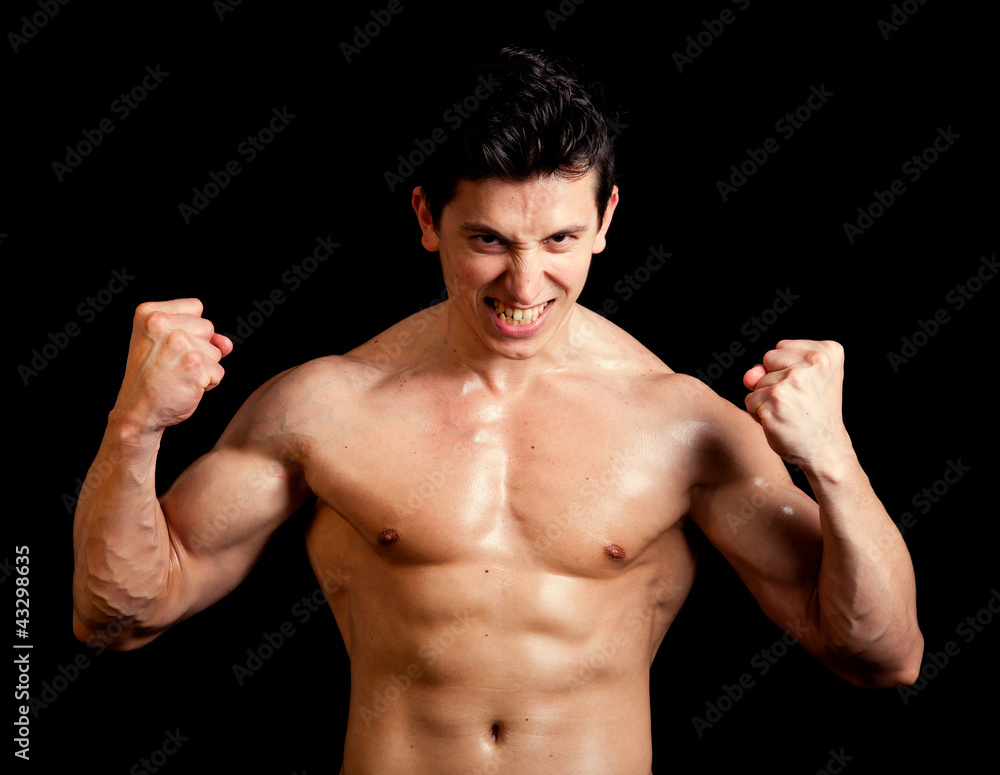 Athletic muscled man against dark background Athletic muscled man against dark background
