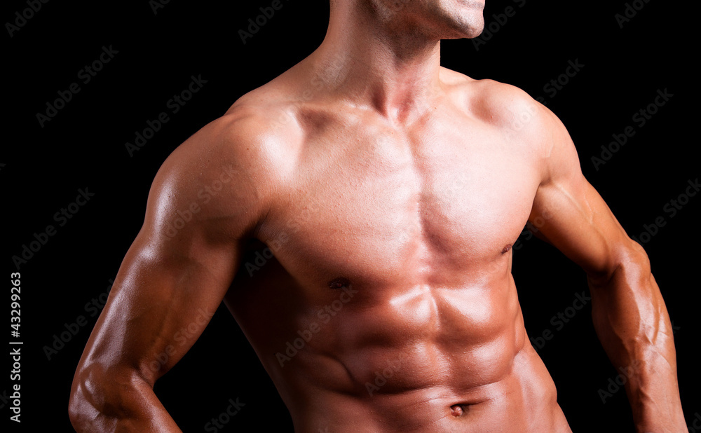 Young muscular man with beautiful torso agaisnt black background Young muscular man with beautiful torso agaisnt black background