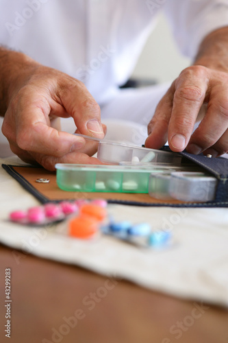Tableau sur toile Old person preparing medication for the week ahead
