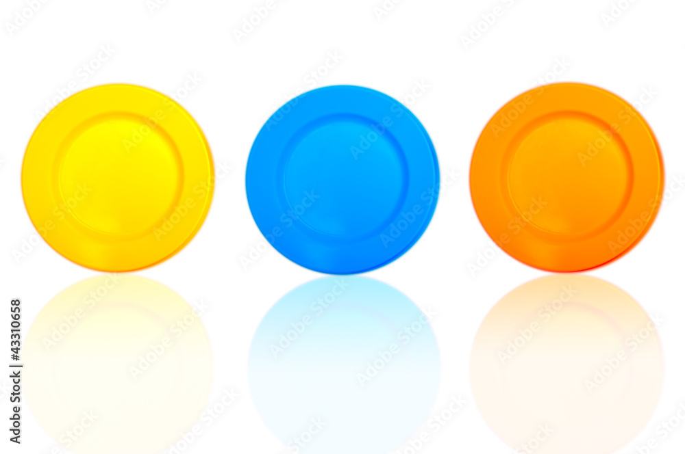yellow , blue and orange plates isolated on a white background yellow , blue and orange plates isolated on a white background