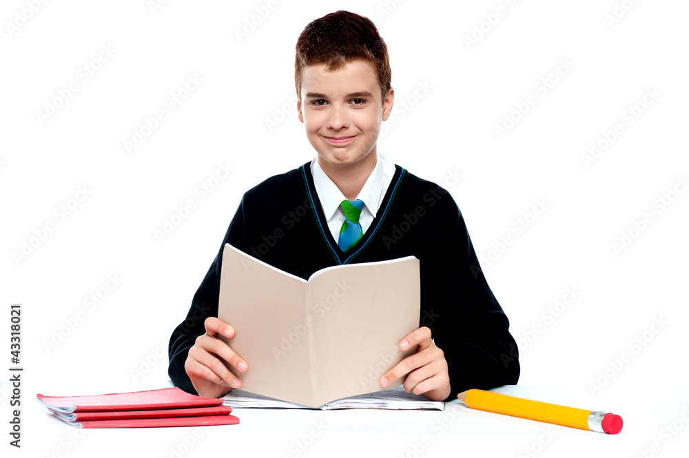 Cute school kid holding notebook and reading Cute school kid holding notebook and reading