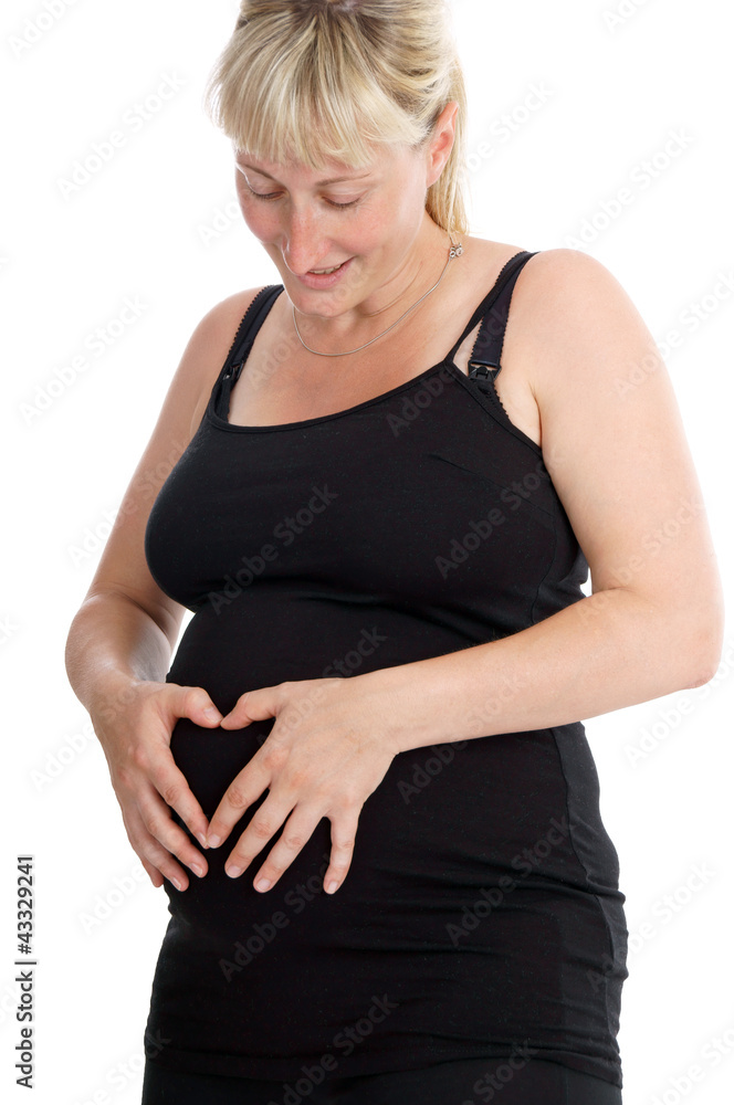 pregnant woman makes a heart with their hands over her belly pregnant woman makes a heart with their hands over her belly
