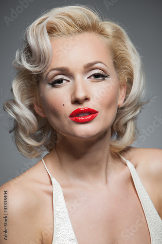 Pretty blond girl model like Marilyn Monroe in white dress with