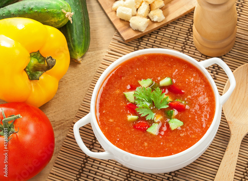 Gazpacho and ingredients on a table, vegetable soup