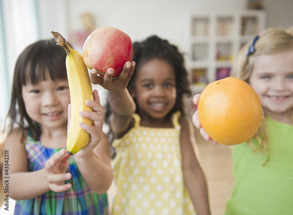 © JGI/Jamie Grill/Blend Images - Children holding out fresh fruit