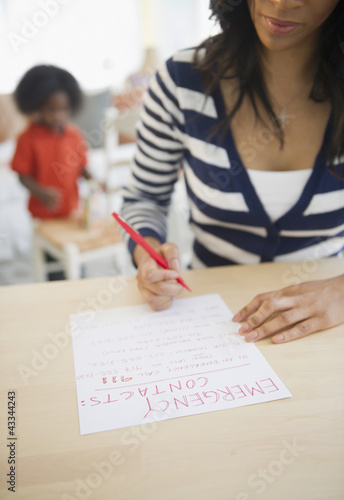 African American woman writing out contact phone numbers photo