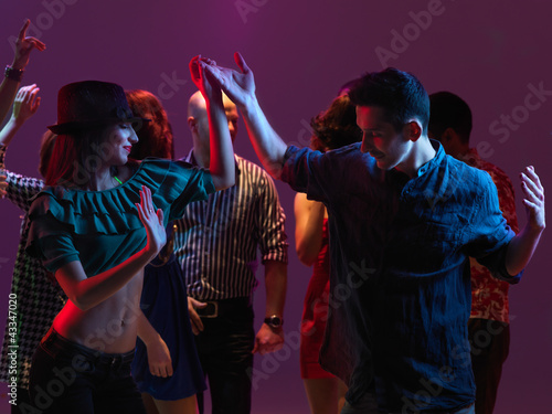 happy young people dancing in night club