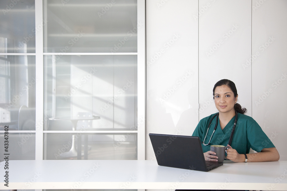 Mixed race doctor using laptop Mixed race doctor using laptop