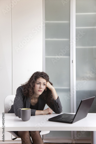 Bored businesswoman sitting at desk