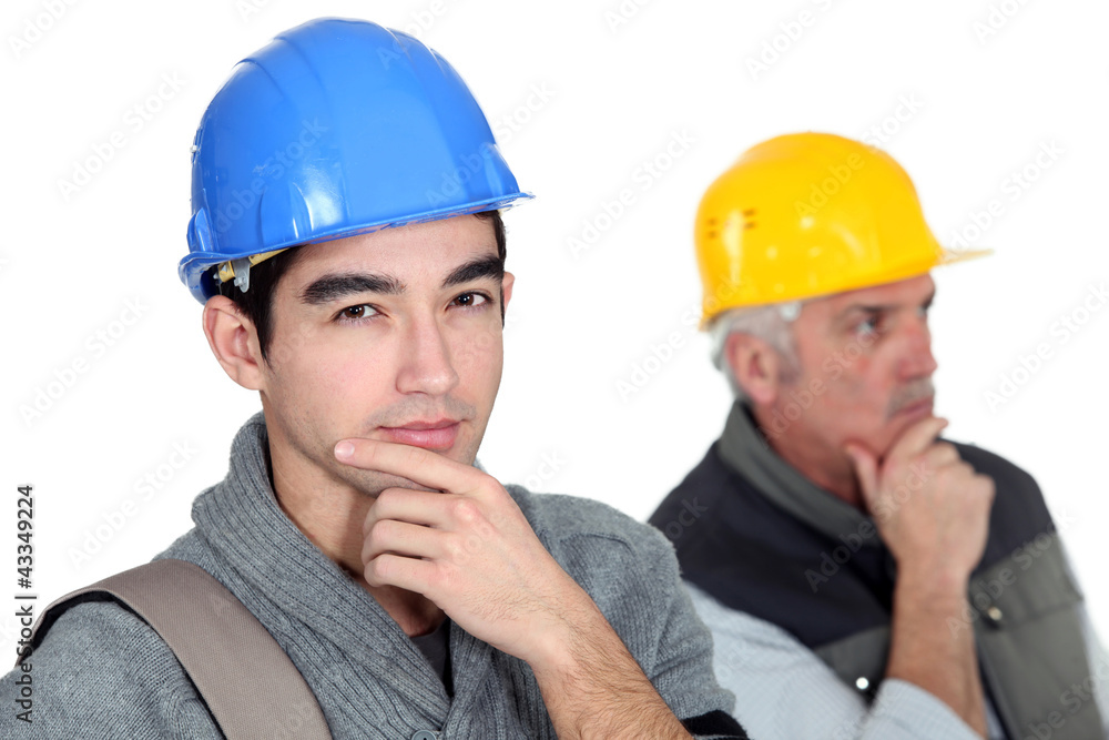 Pensive builder with young intern Pensive builder with young intern
