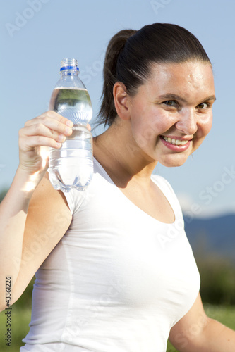 A young sportive girl with a bottle