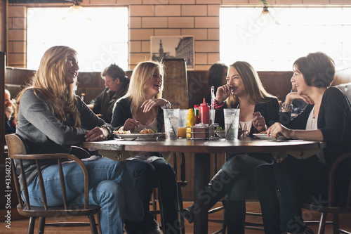 Caucasian teenagers eating together in restaurant photo