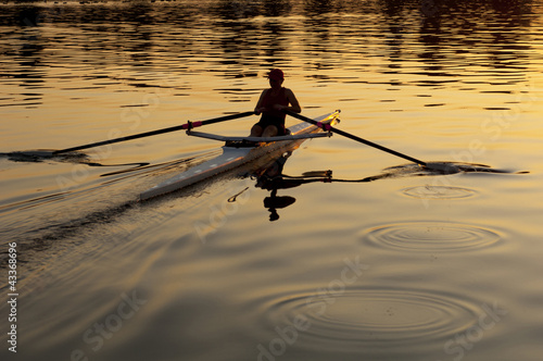 Person rowing sculling boat on river